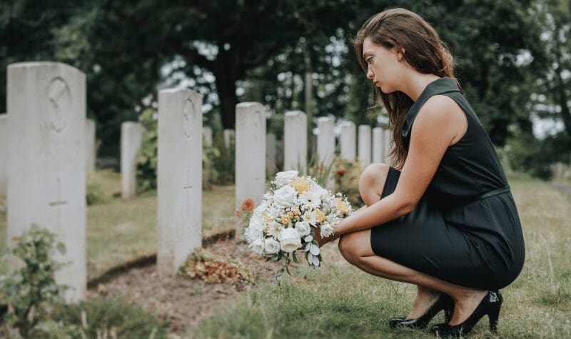 A lady visiting the grave of a loved one killed in an auto accident.